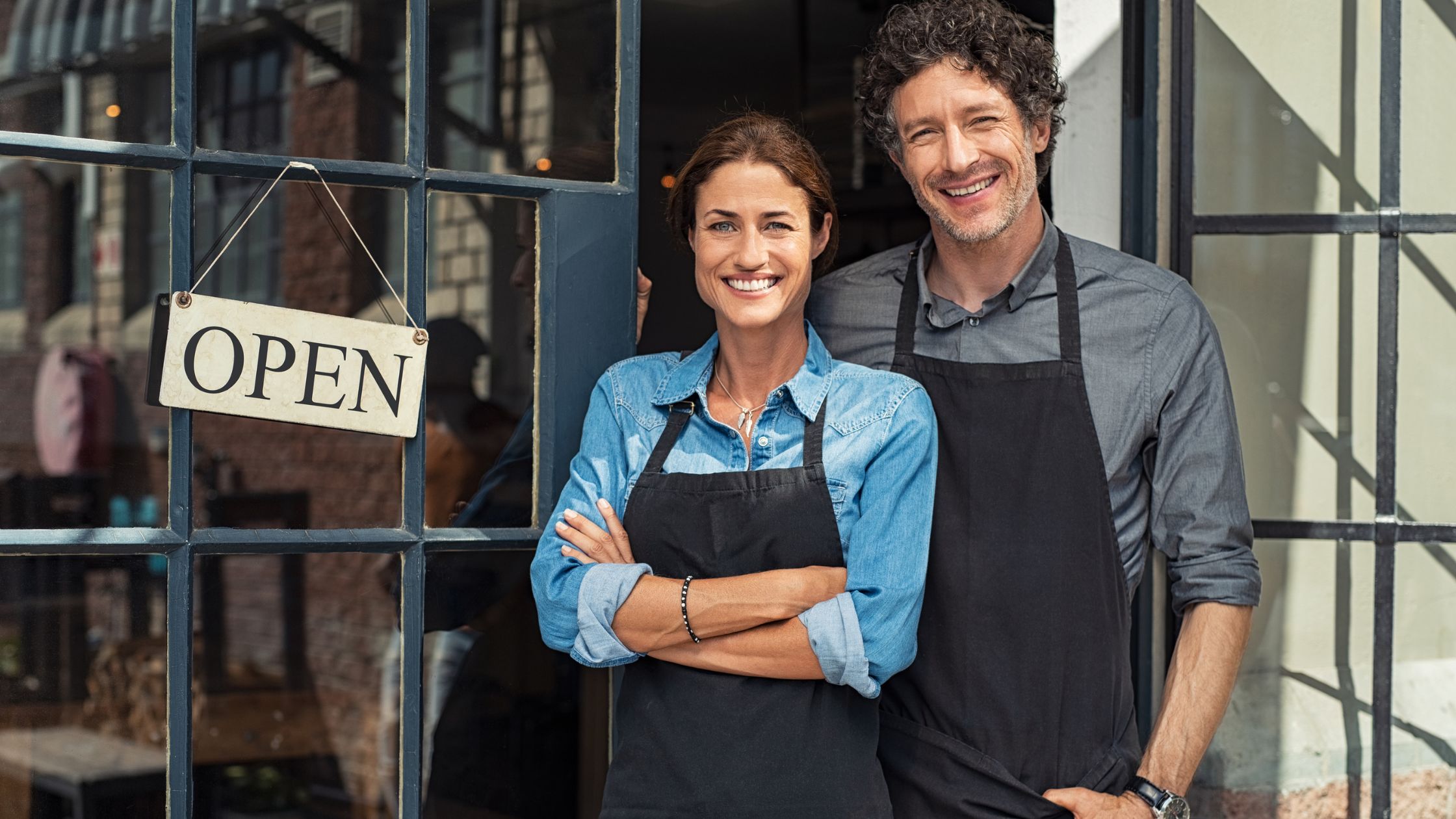 A man and a woman standing in front of their new small business